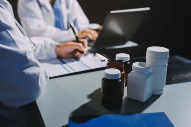 Erkek ve kadın doktorlar bir hastane odasında toplantı yapıyorlar..