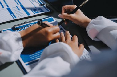 Erkek ve kadın doktorlar bir hastane odasında toplantı yapıyorlar..