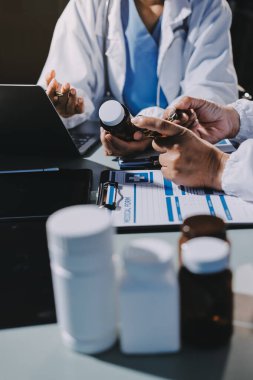 Erkek ve kadın doktorlar bir hastane odasında toplantı yapıyorlar..