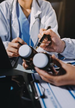 Erkek ve kadın doktorlar bir hastane odasında toplantı yapıyorlar..