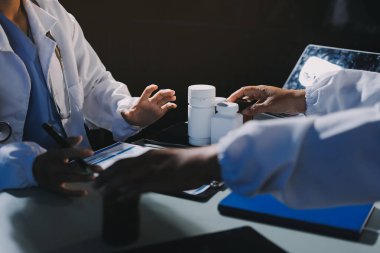 Erkek ve kadın doktorlar bir hastane odasında toplantı yapıyorlar..