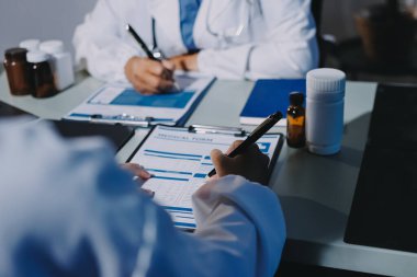 Erkek ve kadın doktorlar bir hastane odasında toplantı yapıyorlar..