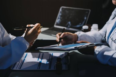 Erkek ve kadın doktorlar bir hastane odasında toplantı yapıyorlar..