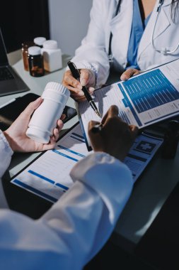 Erkek ve kadın doktorlar bir hastane odasında toplantı yapıyorlar..