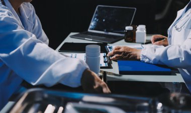 Erkek ve kadın doktorlar bir hastane odasında toplantı yapıyorlar..