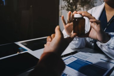 Uzman doktor bir hastaya ilaç götürmeyi açıklıyor. Sağlık ve İlaç danışmanlığı.