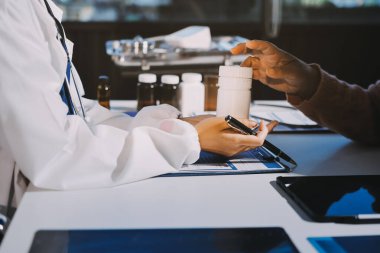 Uzman doktor bir hastaya ilaç götürmeyi açıklıyor. Sağlık ve İlaç danışmanlığı.