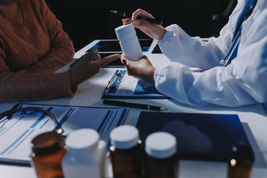 Uzman doktor bir hastaya ilaç götürmeyi açıklıyor. Sağlık ve İlaç danışmanlığı.