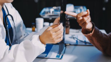 Doktor, emekliye ayrılmış yaşlı kadına akciğer röntgeni çeken hastanın sağlık ve hayat sigortası planlarını kullanarak hastane bakım evindeki hastalara tedavi yöntemlerini anlattı.