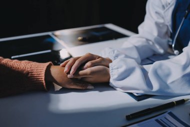 Asyalı kadın elleri yaşlı kadın ellerine dokunuyor hastanede yaşlılara yardım eden eller.