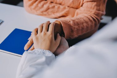 Asyalı kadın elleri yaşlı kadın ellerine dokunuyor hastanede yaşlılara yardım eden eller.