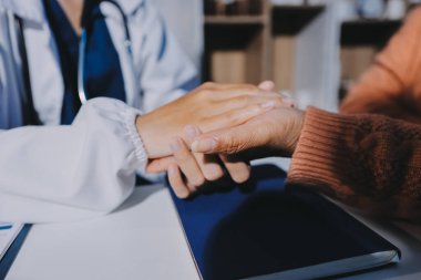 Asyalı kadın elleri yaşlı kadın ellerine dokunuyor hastanede yaşlılara yardım eden eller.