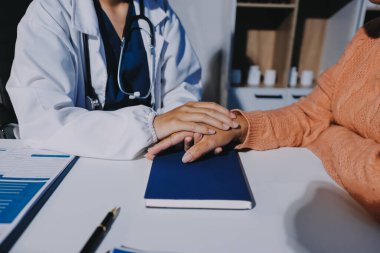 Asyalı kadın elleri yaşlı kadın ellerine dokunuyor hastanede yaşlılara yardım eden eller.