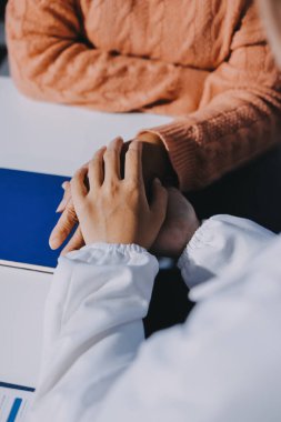 Asyalı kadın elleri yaşlı kadın ellerine dokunuyor hastanede yaşlılara yardım eden eller.