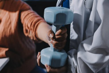 Klinikte dambıllar, fizik tedavi konsepti kullanan hastalarla fizyoterapist eğitimi