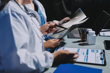 Erkek ve kadın doktorlar bir hastane odasında toplantı yapıyorlar..