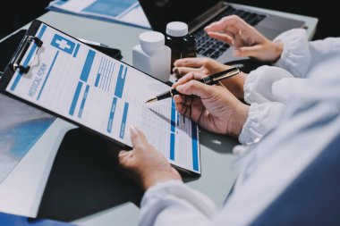 Erkek ve kadın doktorlar bir hastane odasında toplantı yapıyorlar..