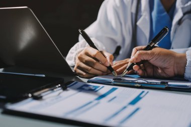 Erkek ve kadın doktorlar bir hastane odasında toplantı yapıyorlar..