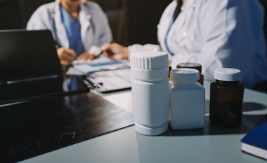 Erkek ve kadın doktorlar bir hastane odasında toplantı yapıyorlar..