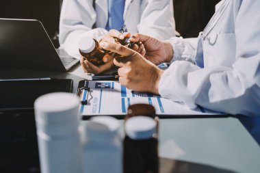 Erkek ve kadın doktorlar bir hastane odasında toplantı yapıyorlar..