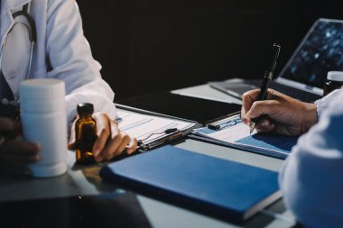 Erkek ve kadın doktorlar bir hastane odasında toplantı yapıyorlar..