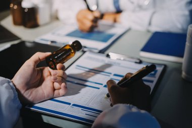 Erkek ve kadın doktorlar bir hastane odasında toplantı yapıyorlar..