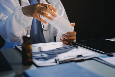 Erkek ve kadın doktorlar bir hastane odasında toplantı yapıyorlar..