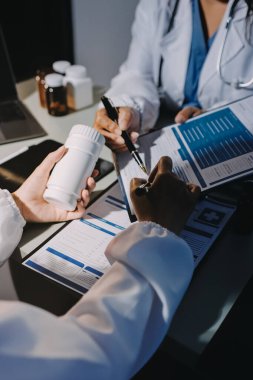 Erkek ve kadın doktorlar bir hastane odasında toplantı yapıyorlar..