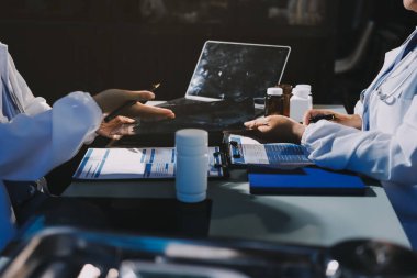 Erkek ve kadın doktorlar bir hastane odasında toplantı yapıyorlar..