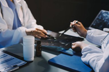 Erkek ve kadın doktorlar bir hastane odasında toplantı yapıyorlar..