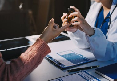 Uzman doktor bir hastaya ilaç götürmeyi açıklıyor. Sağlık ve İlaç danışmanlığı.