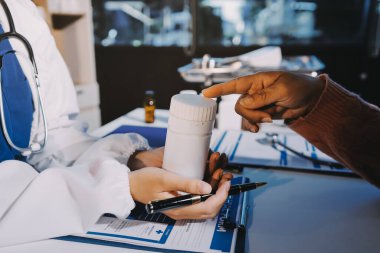 Uzman doktor bir hastaya ilaç götürmeyi açıklıyor. Sağlık ve İlaç danışmanlığı.