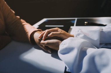 Asyalı kadın elleri yaşlı kadın ellerine dokunuyor hastanede yaşlılara yardım eden eller.