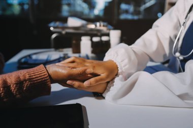 Asyalı kadın elleri yaşlı kadın ellerine dokunuyor hastanede yaşlılara yardım eden eller.