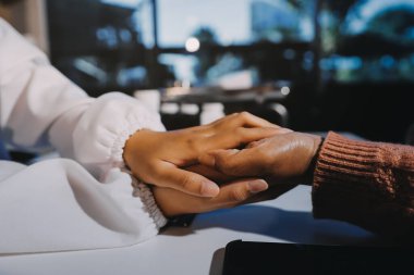 Asyalı kadın elleri yaşlı kadın ellerine dokunuyor hastanede yaşlılara yardım eden eller.