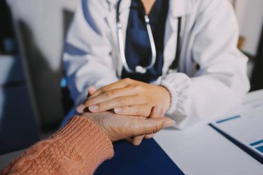 Asyalı kadın elleri yaşlı kadın ellerine dokunuyor hastanede yaşlılara yardım eden eller.