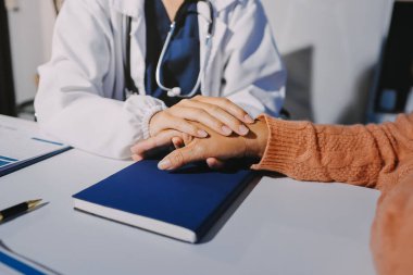 Asyalı kadın elleri yaşlı kadın ellerine dokunuyor hastanede yaşlılara yardım eden eller.