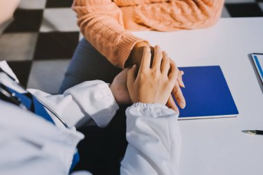 Asyalı kadın elleri yaşlı kadın ellerine dokunuyor hastanede yaşlılara yardım eden eller.