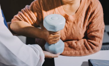 Klinikte dambıllar, fizik tedavi konsepti kullanan hastalarla fizyoterapist eğitimi