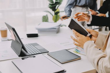 Mali Danışmanlık Servisi ekibi. Danışmanlık bürosundaki müşterilere yatırım planını gösteren Asyalı danışman.