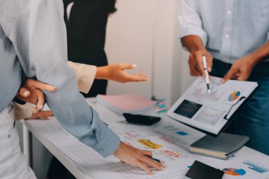 Mali Danışmanlık Servisi ekibi. Danışmanlık bürosundaki müşterilere yatırım planını gösteren Asyalı danışman.