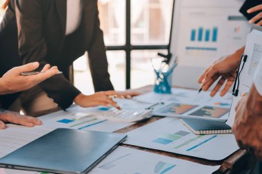 Muhasebe şirketi kazançlı nakit akışı için finansman ve vergilendirme planlaması, ofiste çalışan denetçi ve muhasebeci ekibi, mali verileri ve muhasebe kayıtlarını hesap makinesiyle analiz eder.