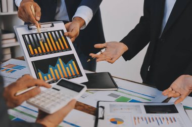 Muhasebe şirketi kazançlı nakit akışı için finansman ve vergilendirme planlaması, ofiste çalışan denetçi ve muhasebeci ekibi, mali verileri ve muhasebe kayıtlarını hesap makinesiyle analiz eder.