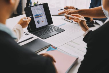 Mali Danışmanlık Servisi ekibi. Danışmanlık bürosundaki müşterilere yatırım planını gösteren Asyalı danışman.