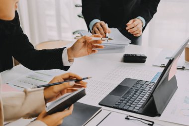 Mali Danışmanlık Servisi ekibi. Danışmanlık bürosundaki müşterilere yatırım planını gösteren Asyalı danışman.