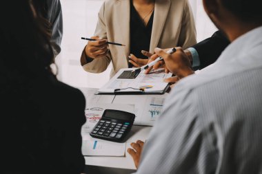 Mali Danışmanlık Servisi ekibi. Danışmanlık bürosundaki müşterilere yatırım planını gösteren Asyalı danışman.