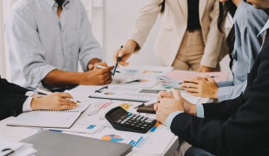 Mali Danışmanlık Servisi ekibi. Danışmanlık bürosundaki müşterilere yatırım planını gösteren Asyalı danışman.