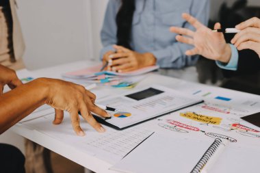 Mali Danışmanlık Servisi ekibi. Danışmanlık bürosundaki müşterilere yatırım planını gösteren Asyalı danışman.