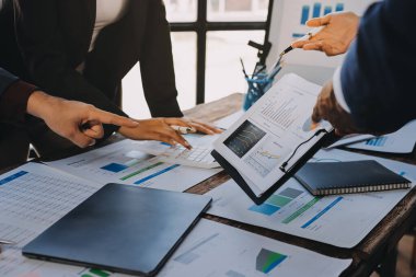 Muhasebe şirketi kazançlı nakit akışı için finansman ve vergilendirme planlaması, ofiste çalışan denetçi ve muhasebeci ekibi, mali verileri ve muhasebe kayıtlarını hesap makinesiyle analiz eder.