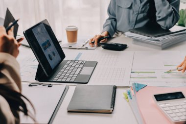 Mali Danışmanlık Servisi ekibi. Danışmanlık bürosundaki müşterilere yatırım planını gösteren Asyalı danışman.